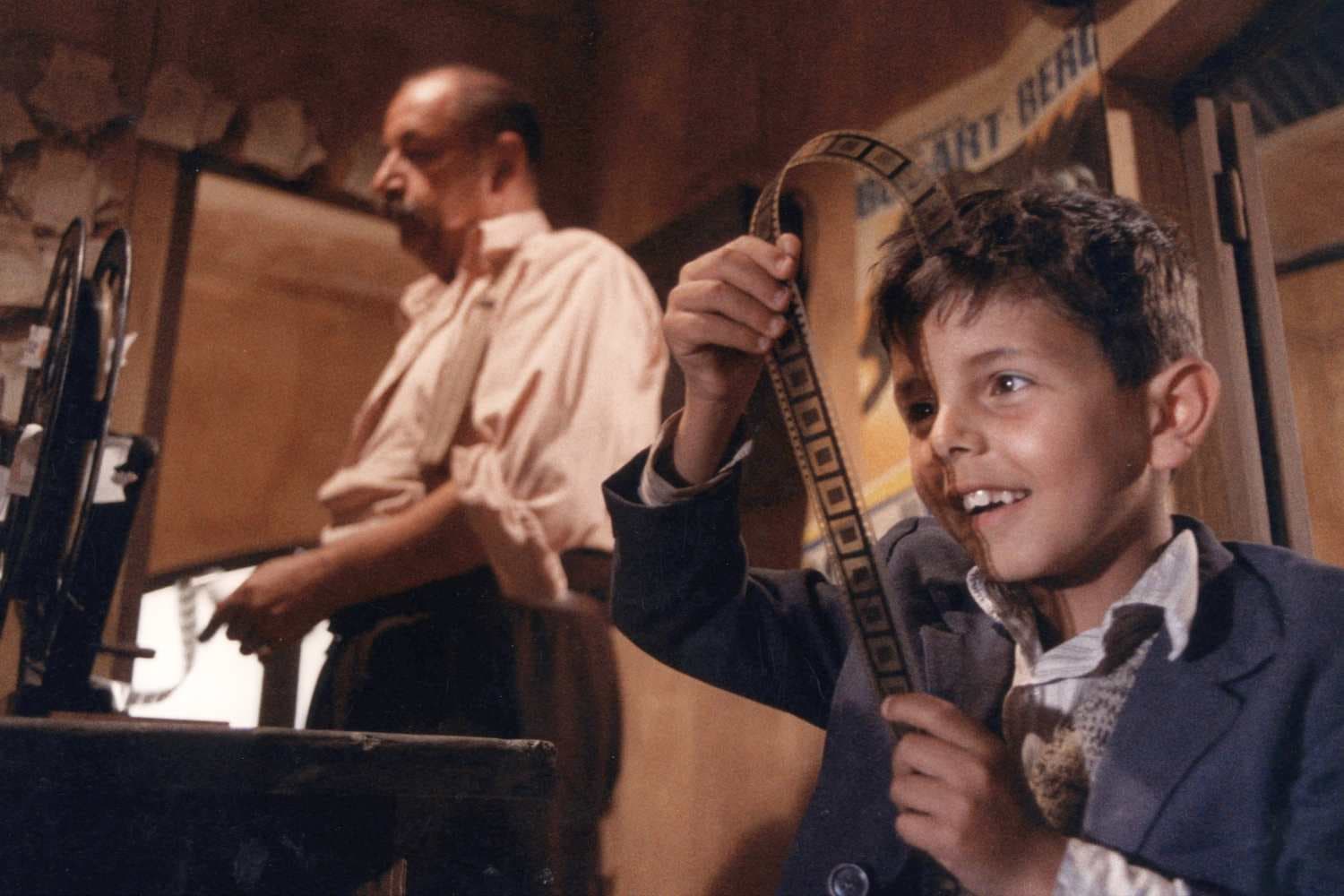 Still from Cinema Paradiso: Alfredo and young Salvatore winding film tape in the projection booth